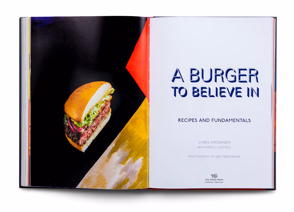 Open cookbook titled 'A Burger to Believe In' with a photo of a hamburger on the left page.