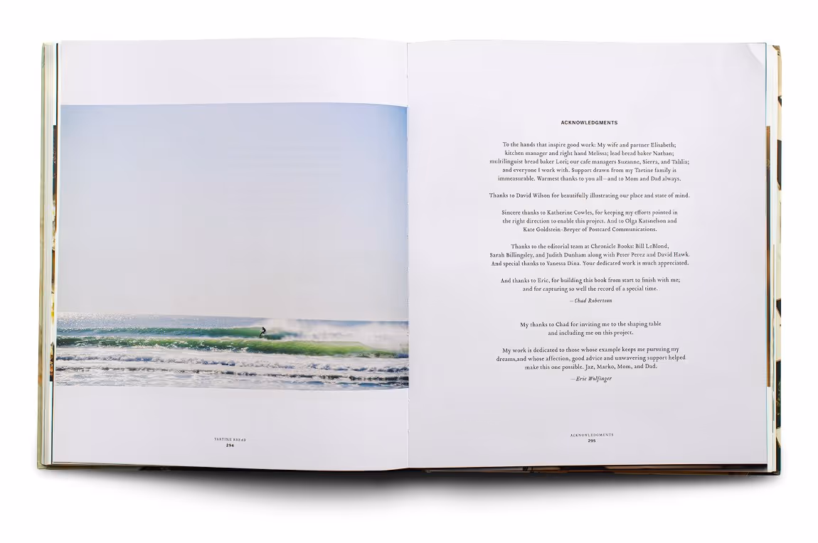 Open book showing a photo of a surfer riding a wave on the left page and an acknowledgments text on the right page.