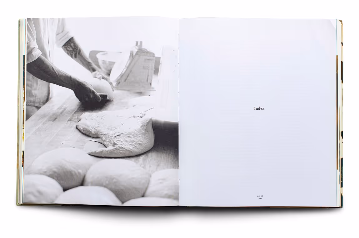 Open book showing a black and white photo of hands working with dough on a wooden surface on the left page, and the word 'Index' printed on the right page.