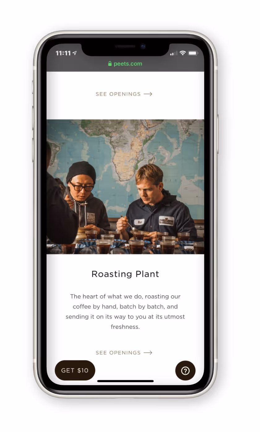 Two people in a coffee roasting plant cupping and tasting coffee with a world map in the background.