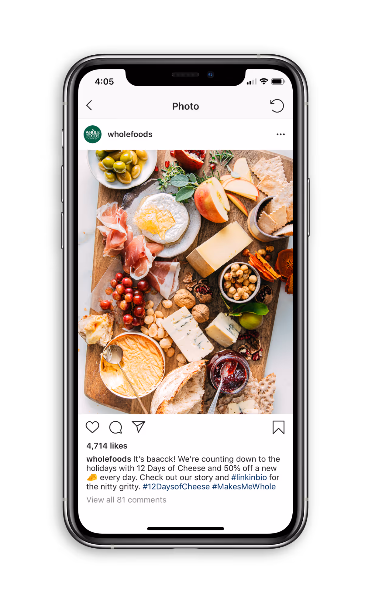 Instagram post by Whole Foods featuring a festive wooden board with assorted cheeses, cured meats, grapes, nuts, crackers, olives, sliced apple, and jam jar on a white surface.
