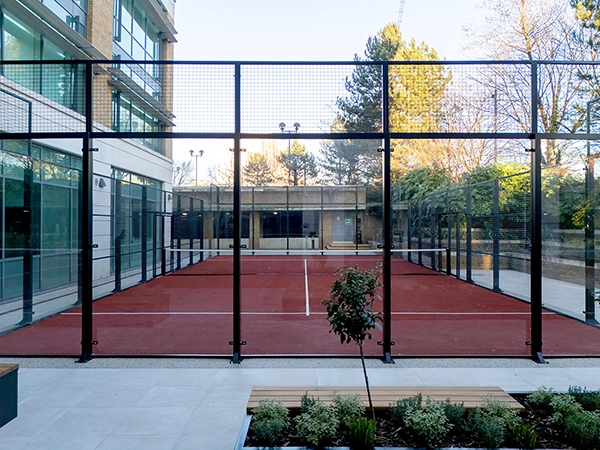 Court shown from outside, looking down the court. Dark red turf