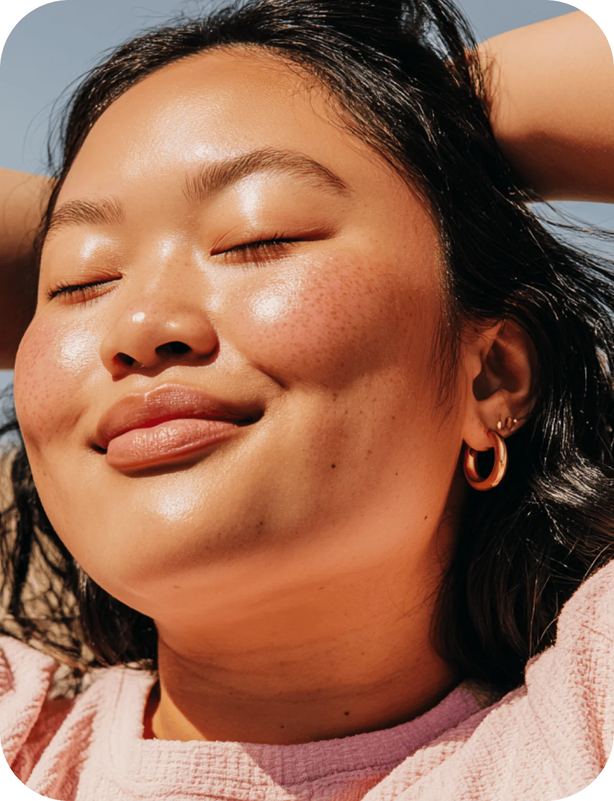 Une femme prend un moment pour elle, le visage au soleil.