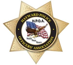 Badge of the Hayward Police Officers' Association featuring an eagle flying in front of an American flag with the words Honor, Pride, Dignity.