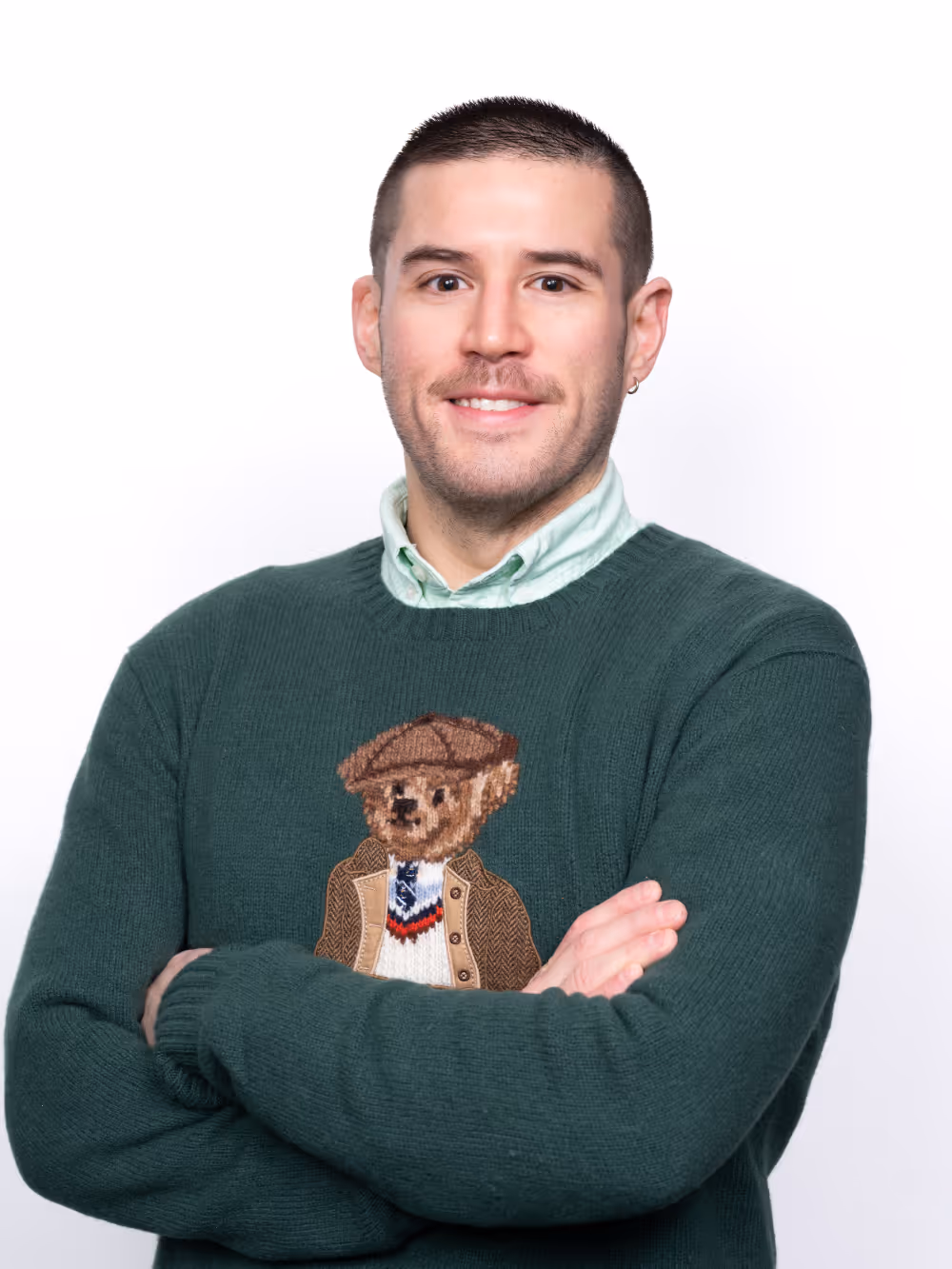 Man in green Polo Bear sweater smiling with arms crossed, representing Point MSP's friendly NYC IT support team