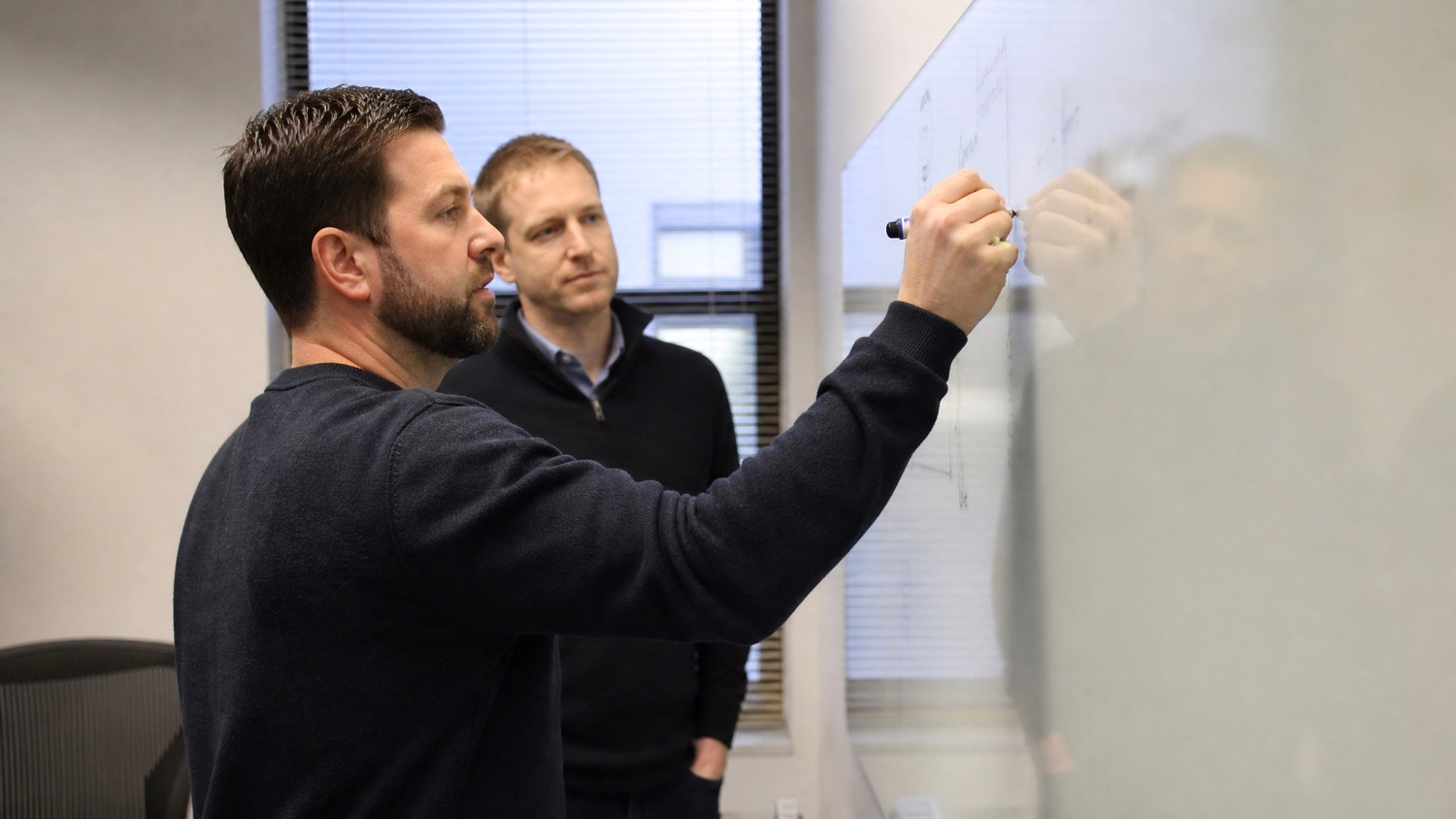 WHITEBOARD SESSION An IT professional  one or two people standing at a whiteb