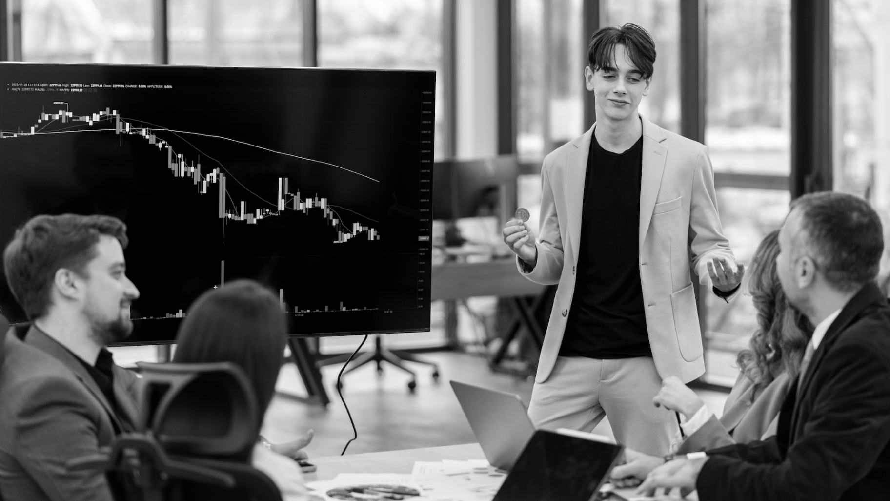 Young worker leading business meeting about cryptocurrencies in an office
