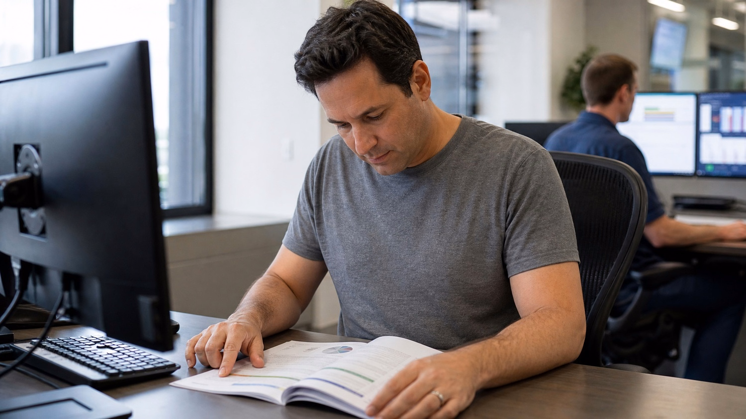 Man reviews printed project plan at desk