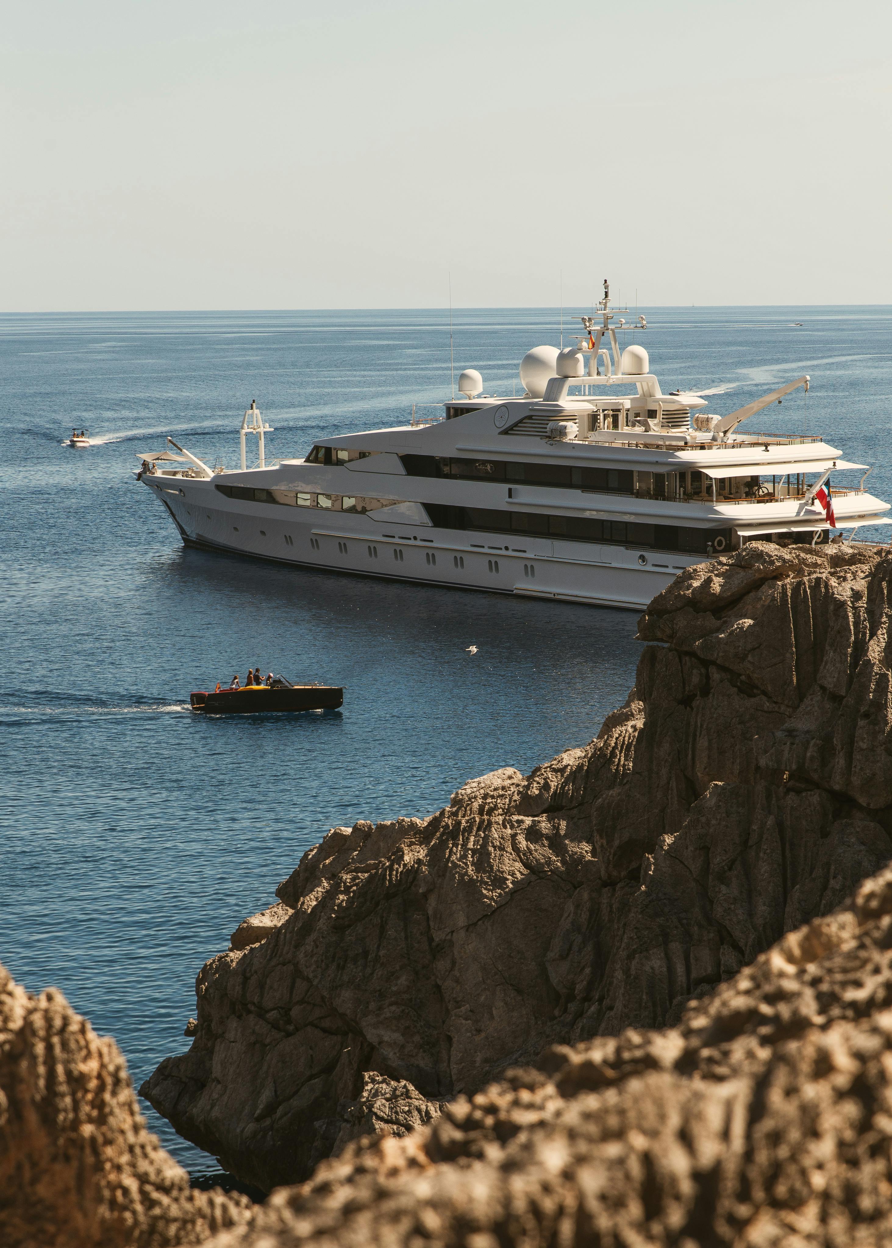 image of yacht behind rocks