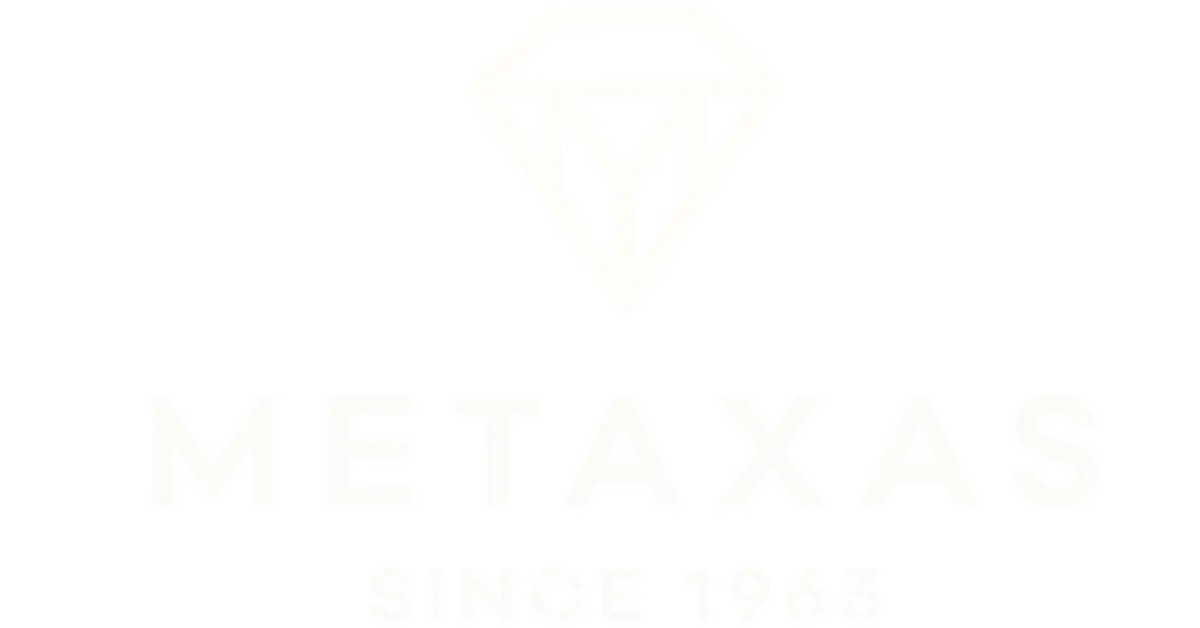 White Metaxas logo featuring a diamond shape with a stylized 'M' and the text 'METAXAS SINCE 1963' below it on a black background.