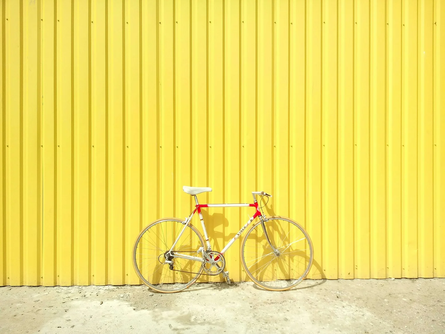 Bicycle in front of a yellow wall