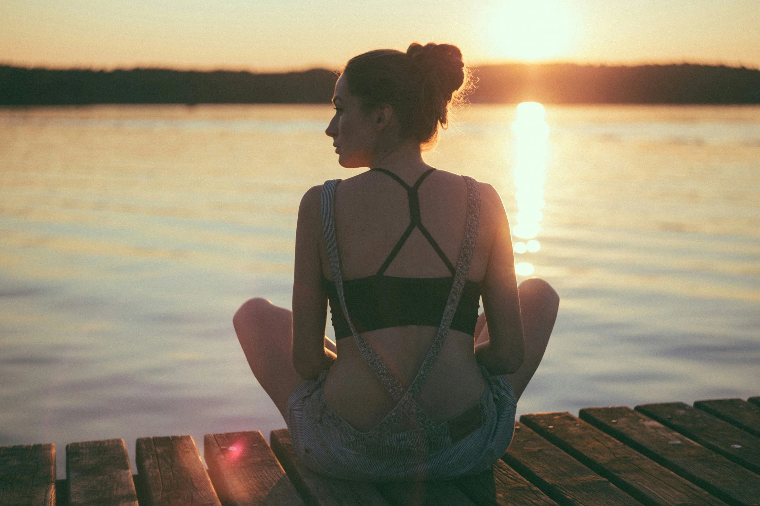 Woman sitting quietly looking at the sunset
