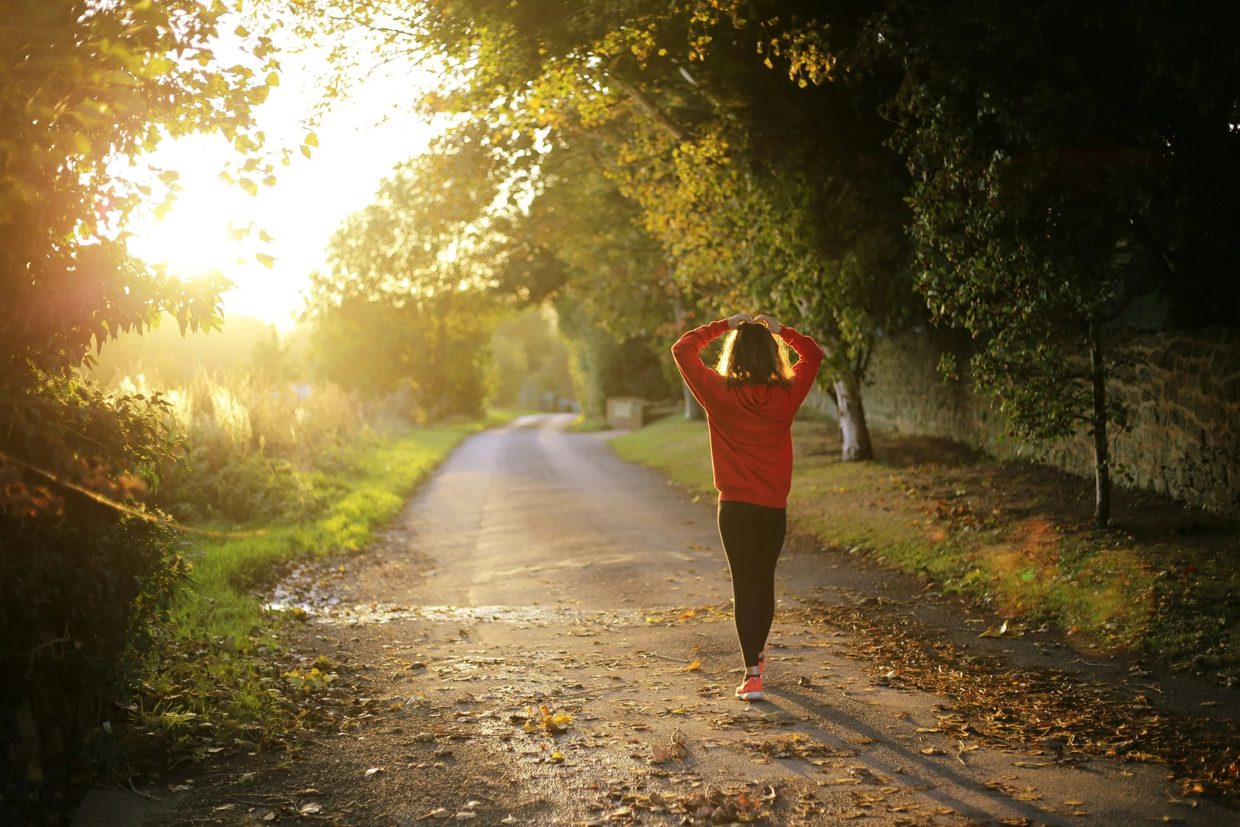Woman walking towards sunlight
