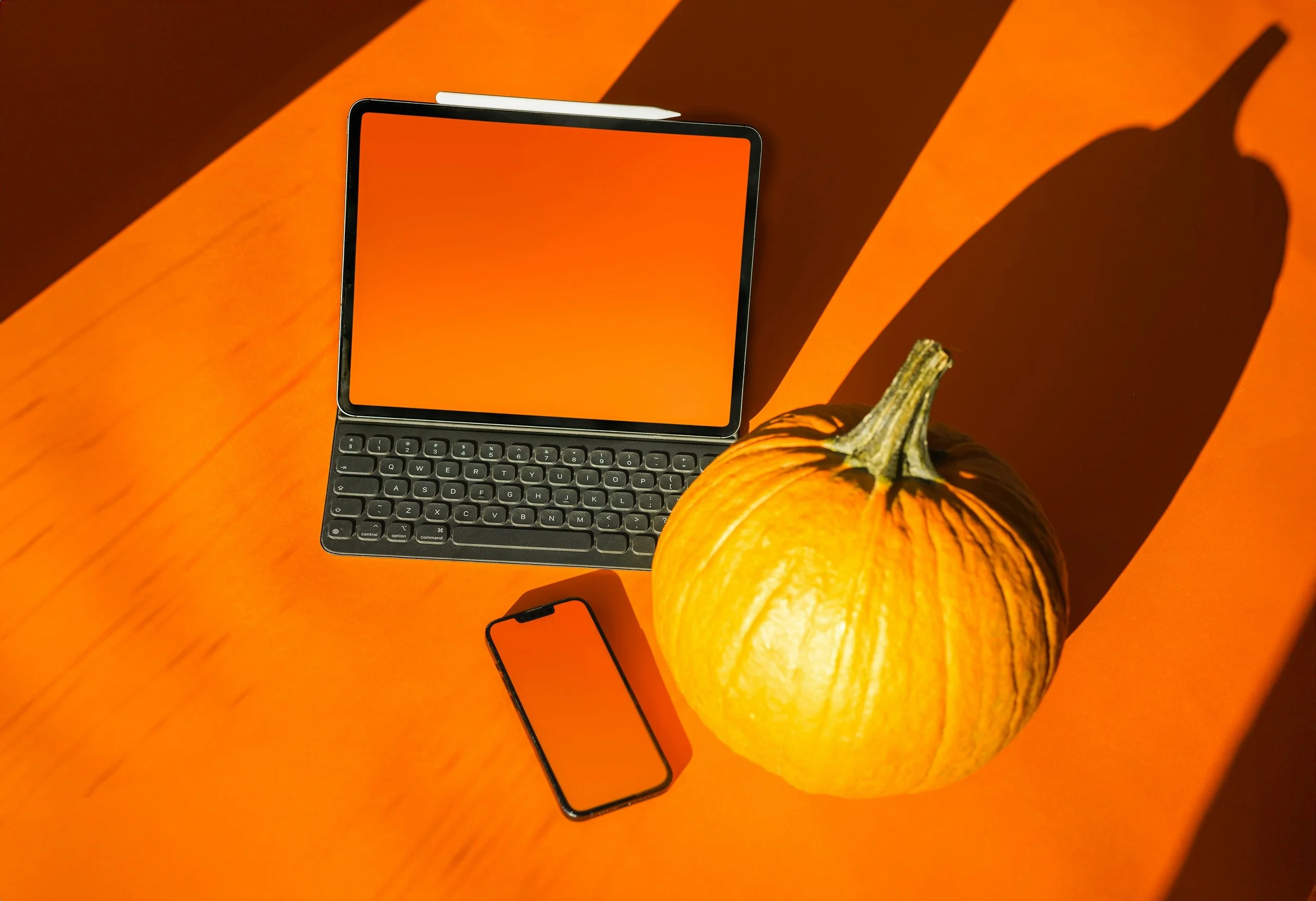 Orange background, pumpkin with laptop & phone