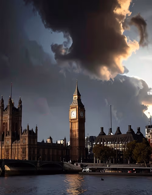 Big Ben clock tower and the Houses of Parliament in London under dramatic dark clouds with sunlight reflecting on the river.