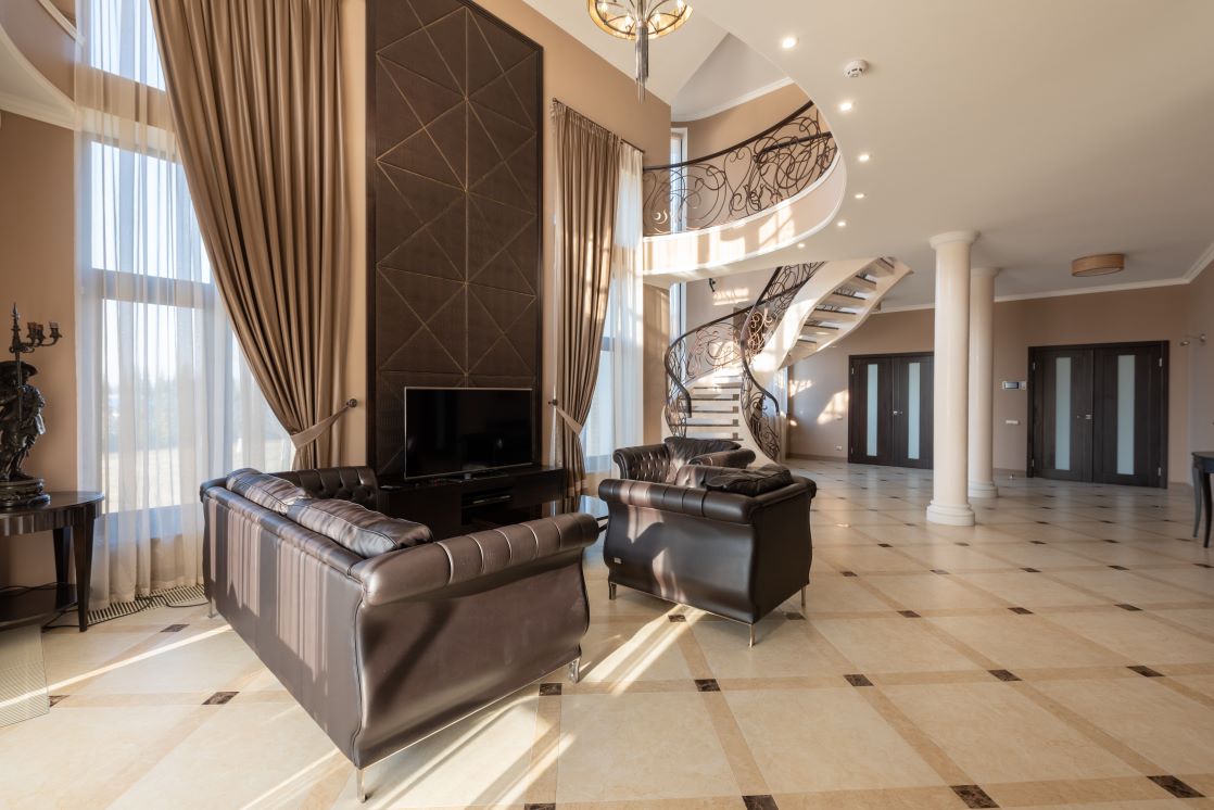 Spacious luxury living room featuring a modern spiral staircase and elegant leather furniture.
