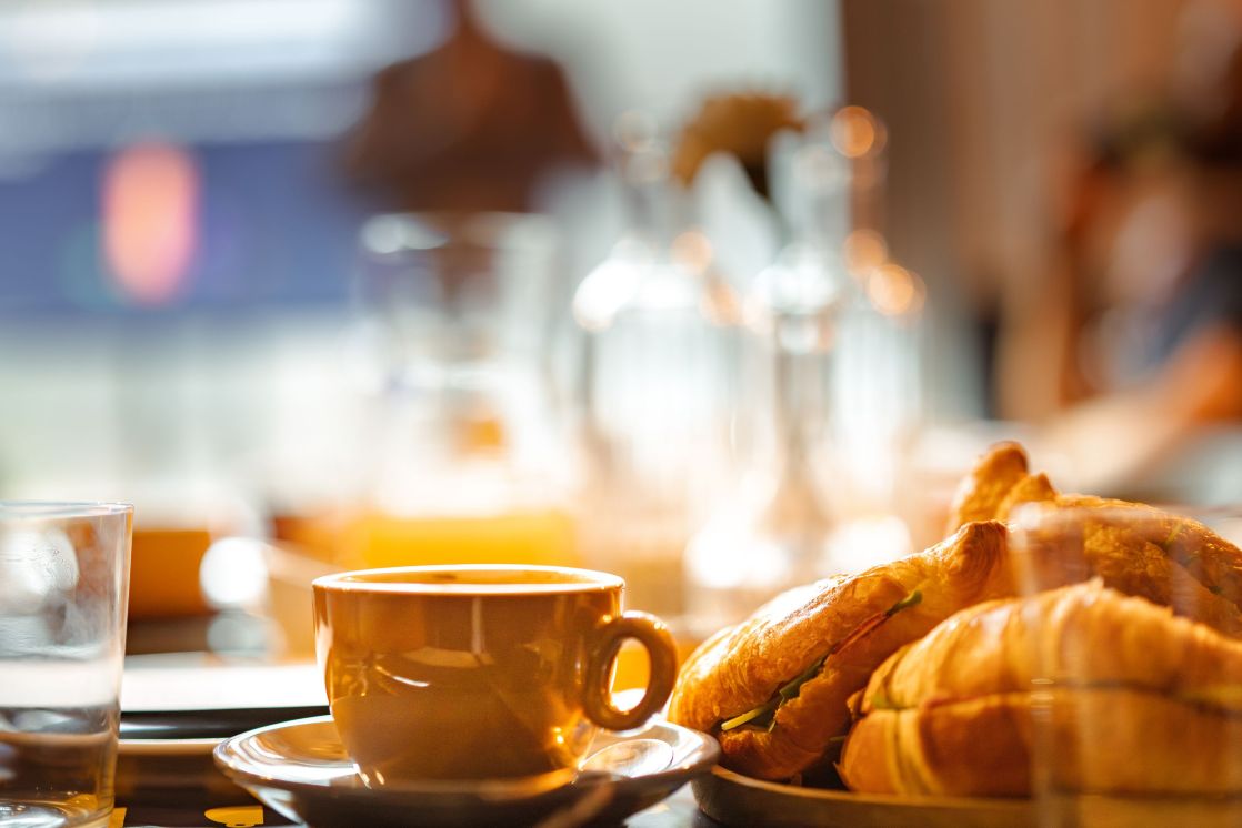 Warm and inviting café scene featuring a cup of coffee and croissants. Perfect for breakfast vibes.
