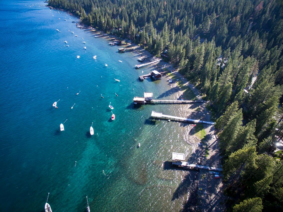 Stunning aerial shot of Lake Tahoe's forested shoreline and boats during summer.
