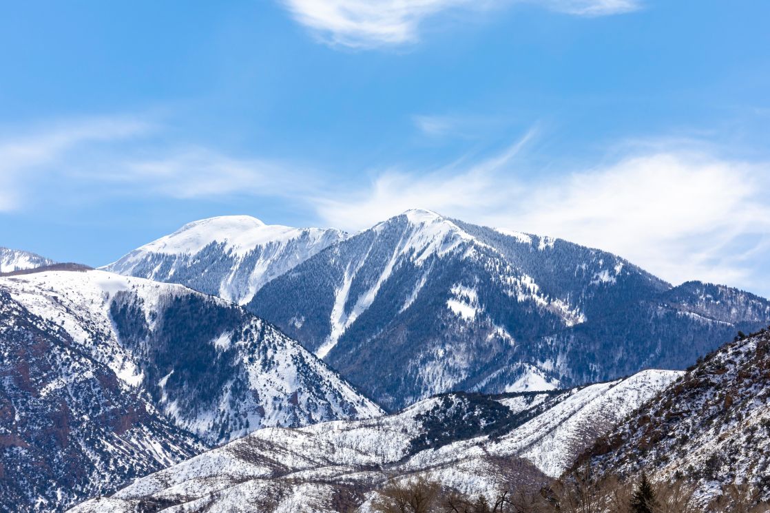 Breathtaking view of snow-covered mountain peaks under a bright blue sky, perfect for winter adventures.