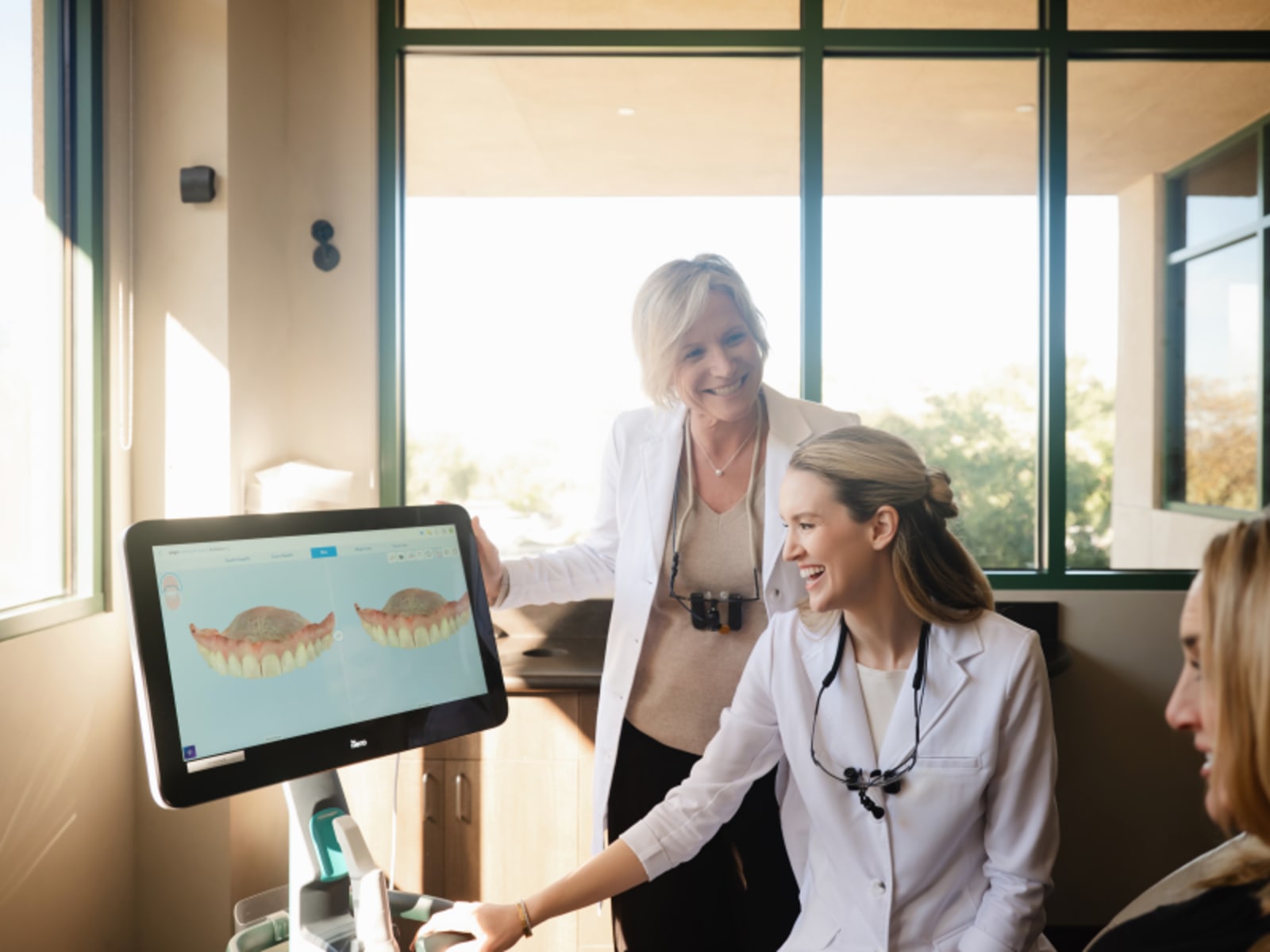 Female dentist explaining treatment options to patient using tablet computer