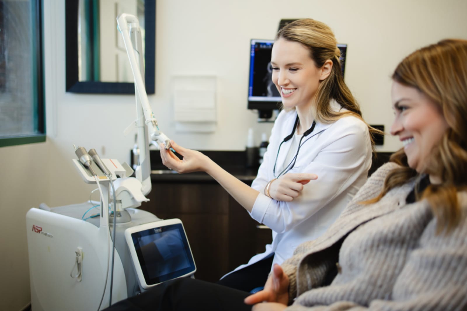 Team member demonstrating dental implant model to patient