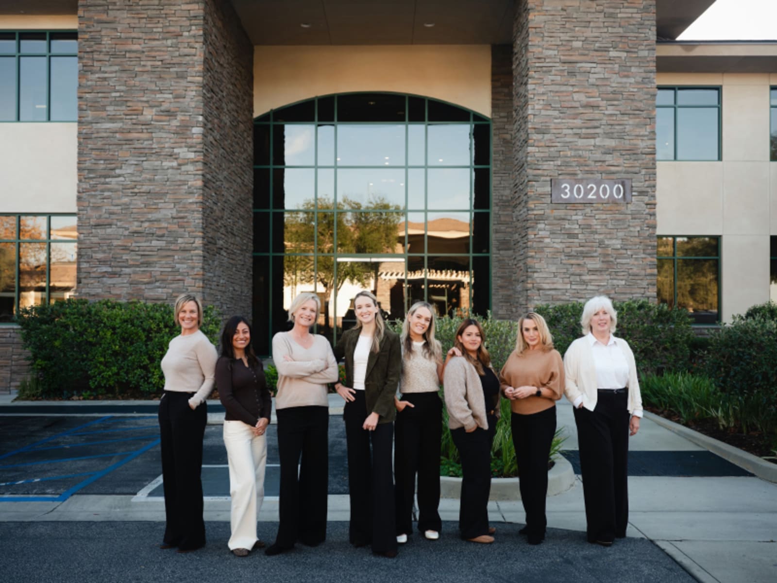 Restore Dental Studio team members standing together outside the modern brick dental office building in Agoura Hills.