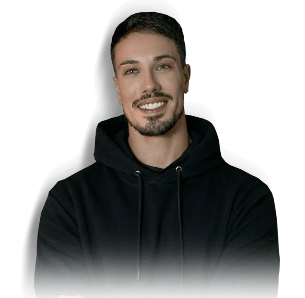 Smiling man with short dark hair and beard wearing a black hoodie on a black background.