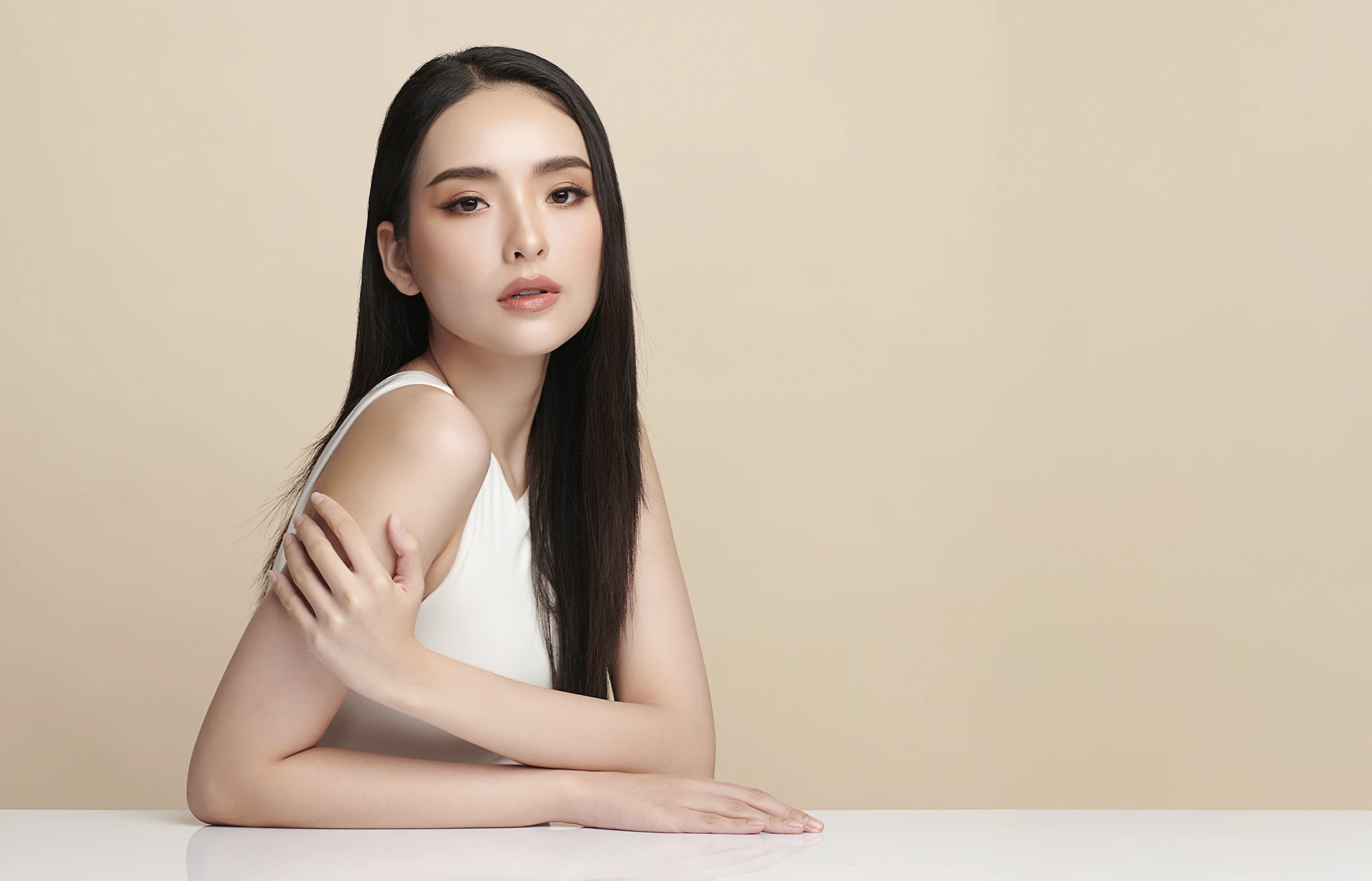 woman with arm on white counter touching arm