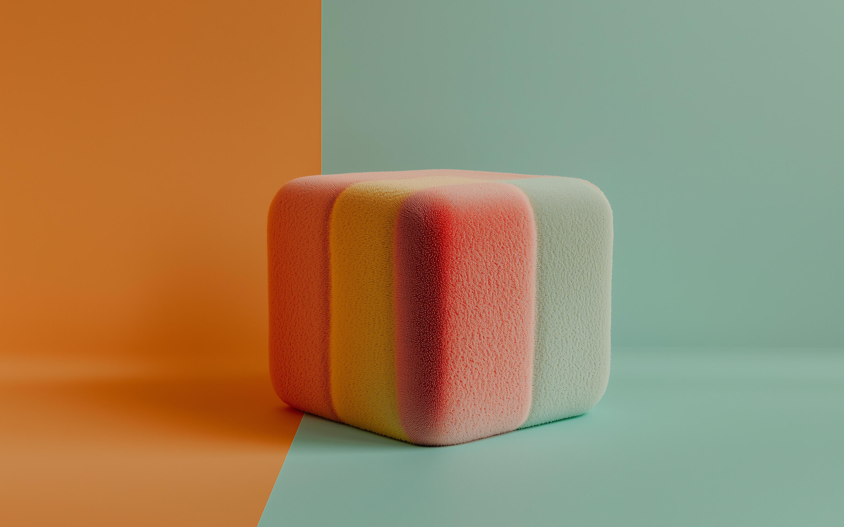 Soft textured cube with gradients of orange, yellow, pink, and light blue on a split orange and light blue background.