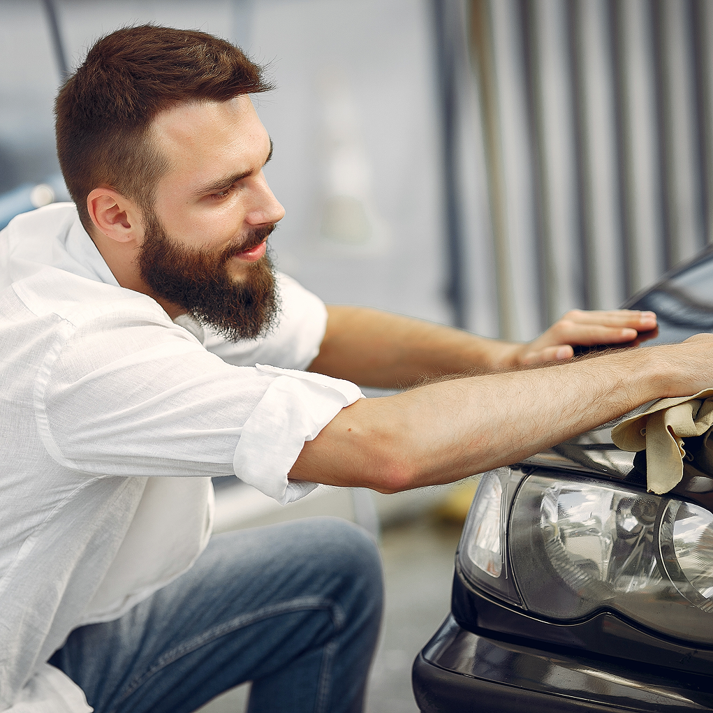 Zadowolony klient po uzyskaniu kredytu gotówkowego, czyszczący swój nowy samochód