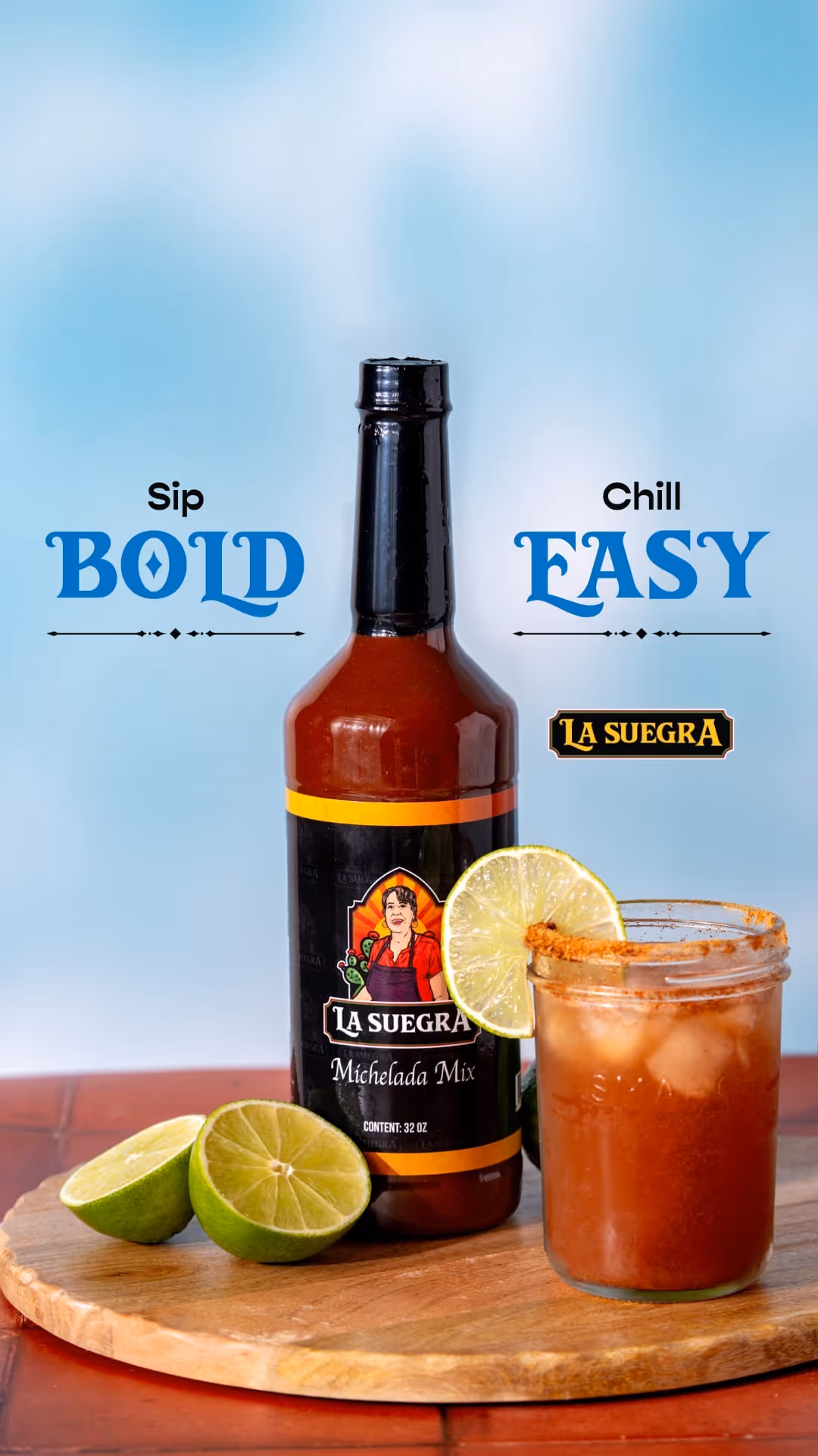 Bottle of La Suegra Michelada Mix with lime halves and a spiced Michelada drink garnished with a lime slice on a wooden board.
