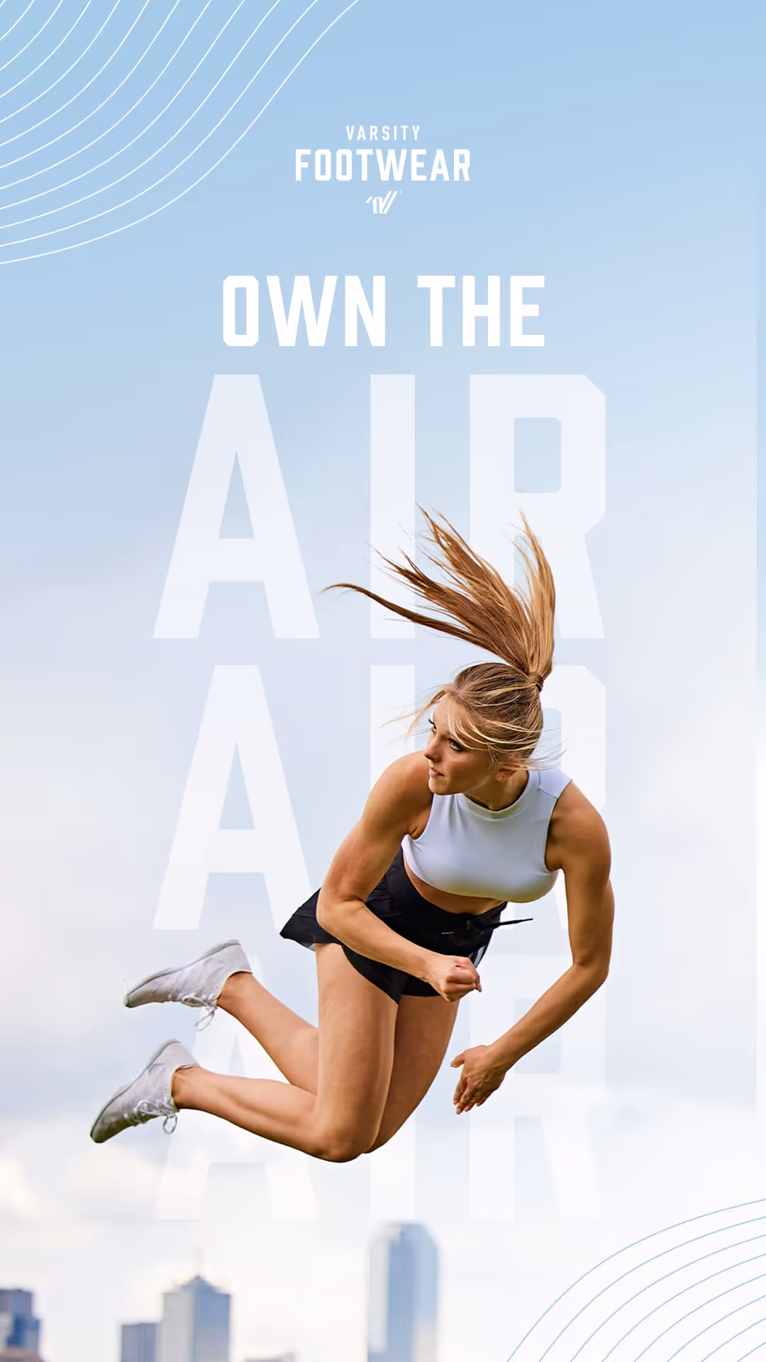 Athletic woman mid-air jump wearing white sneakers, white crop top, and black shorts with city skyline background.