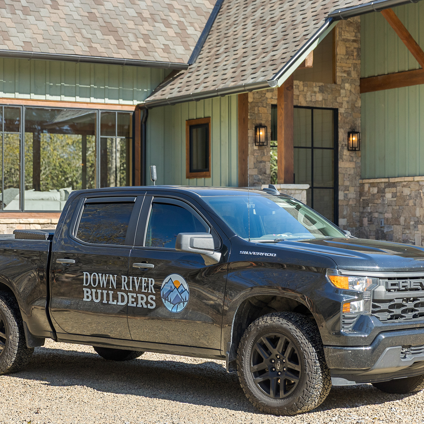A close up shot of a custom home with a work truck belonging to Down River Builders.