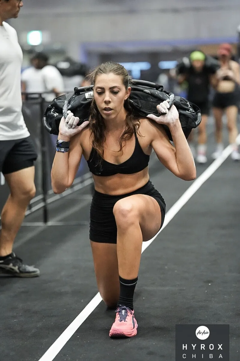 Chelsea Ribeiro doing weighted lunges in a HYROX race