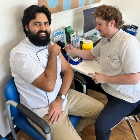 Pharmacist administering a vaccination to a customer at Lismore Pharmacy