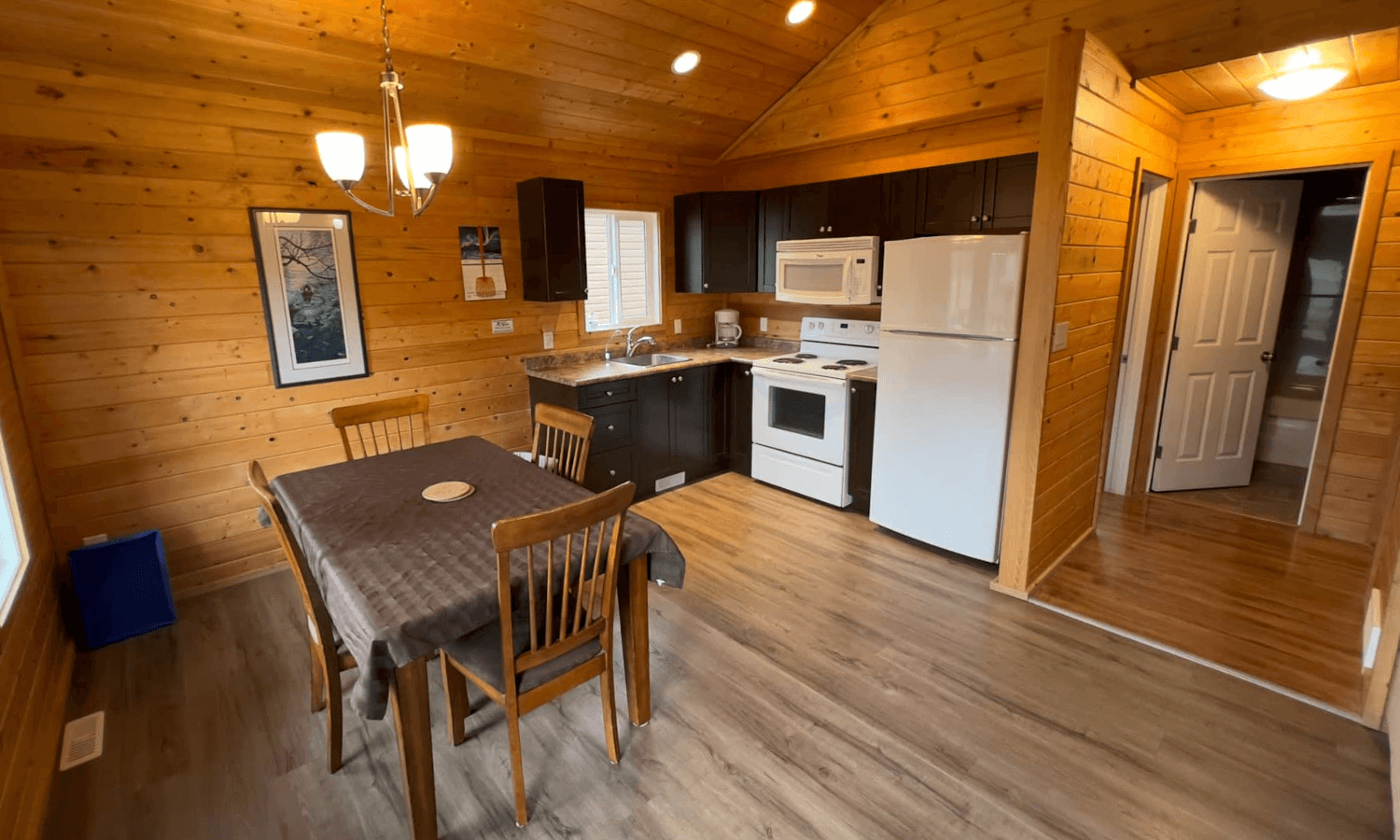wood-paneled cabin kitchen and dining area with full-sized appliances