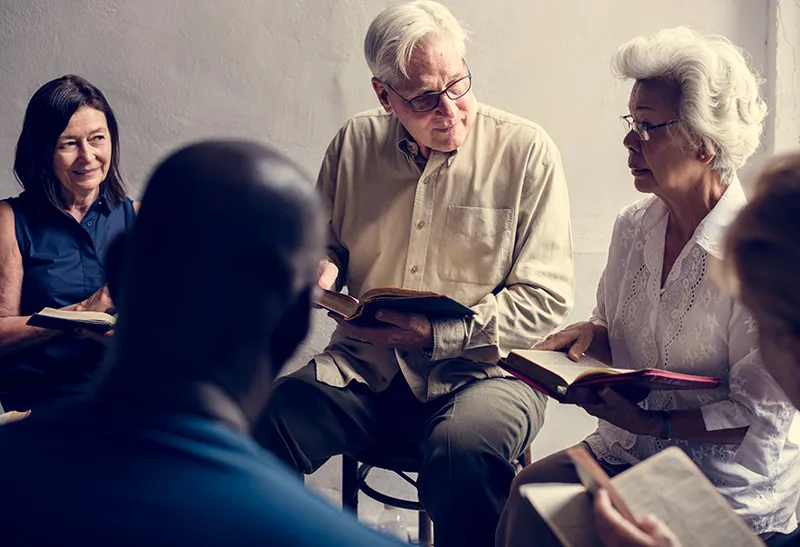 Group of people. men and women sitting on chairs in a circle studding the Bible at Dynamic Faith Ministries