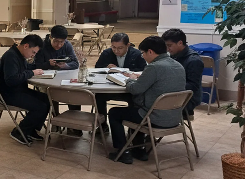 Group of middle-aged to a younger generation sitting on chairs at Grace Chapel discussing the Bible at Dynamic Faith Ministries, Bible study