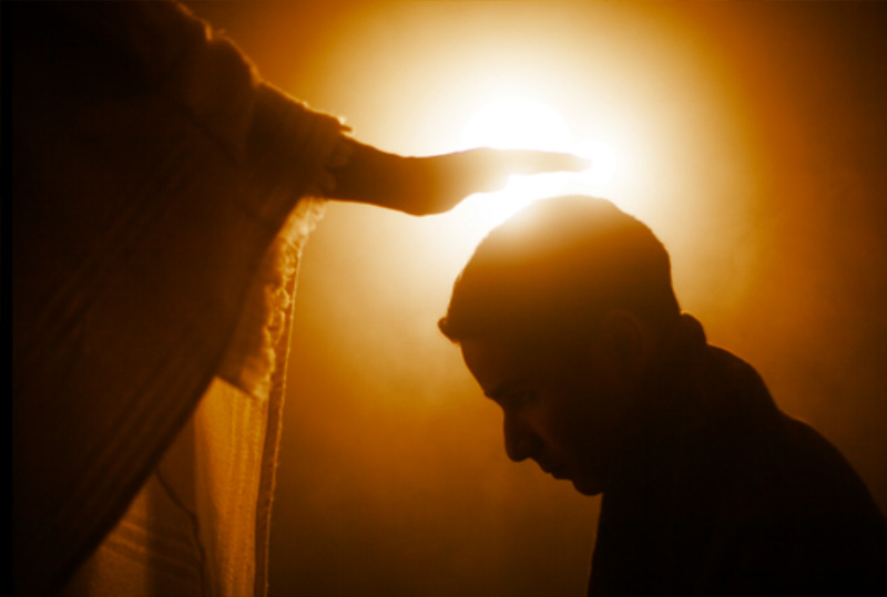 People with their hands folded over their Bibles at Dynamic Faith Ministries