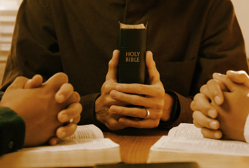 Family sitting at their table with a Bible on the table after the left the Dynamic Faith Ministries Bible study