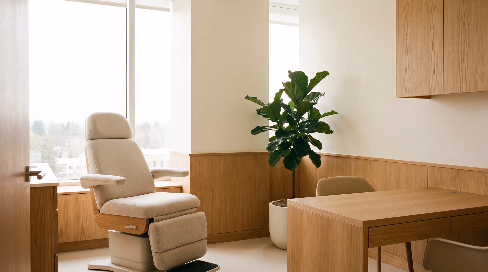 A calm, modern dermatology consultation room filled with natural daylight