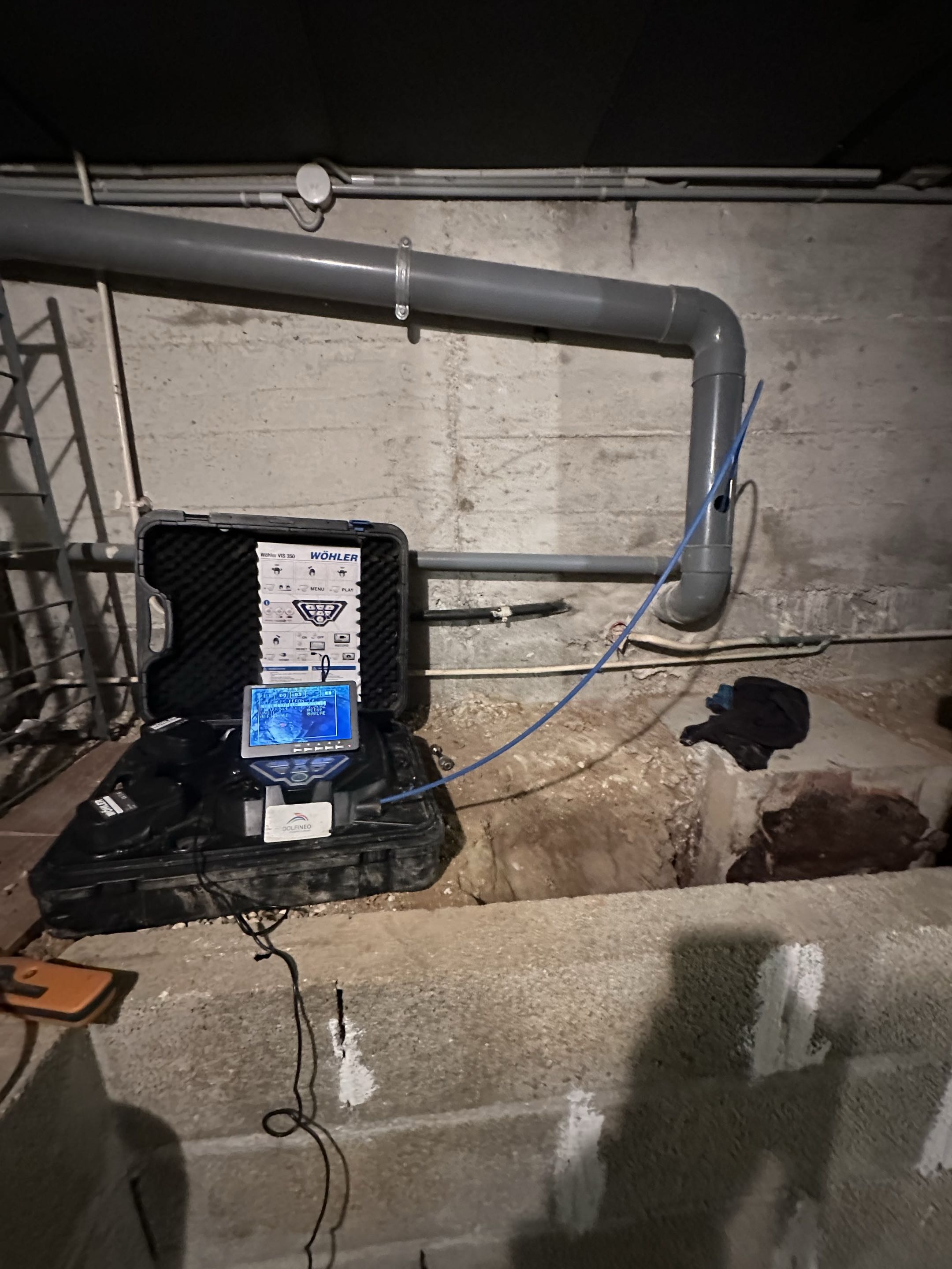 Man in yellow hard hat and gloves installing or fixing a light bulb on a ceiling.