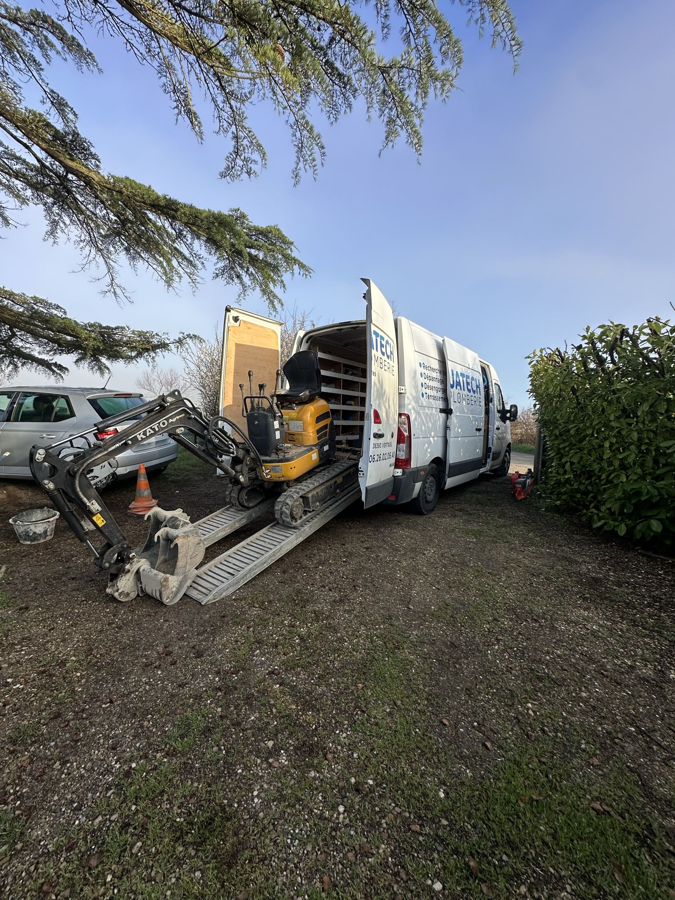 Man wearing safety glasses and gloves installing flooring near a staircase with tools and a toolbox nearby.