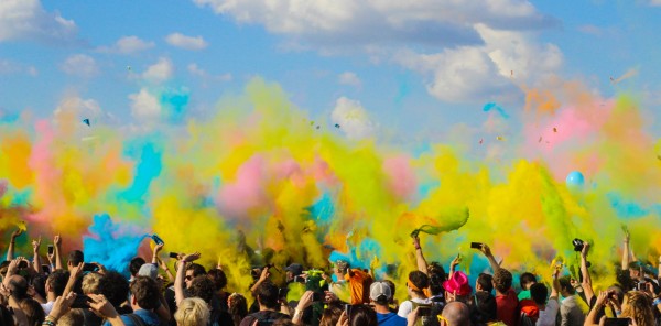 Crowd celebrating festival with colored powder in the air