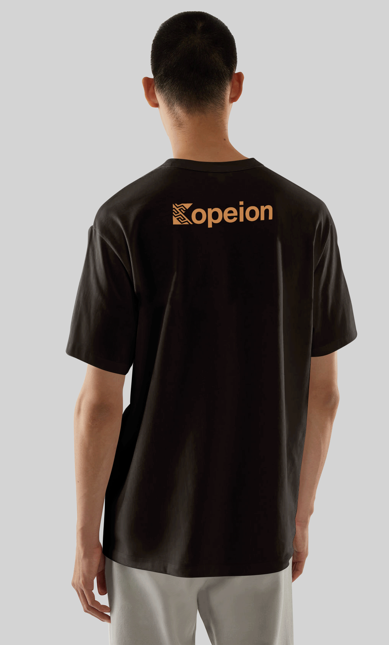 Чоловік спиною у чорній футболці з помаранчевим логотипом 'opeion' на спині, сіра фон.