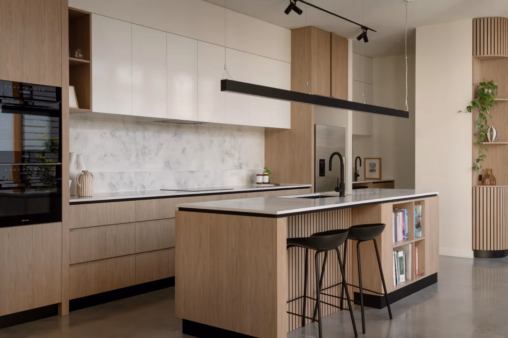 The team of architects at FOLAR standing in the kitchen of a home they designed in Brisbane