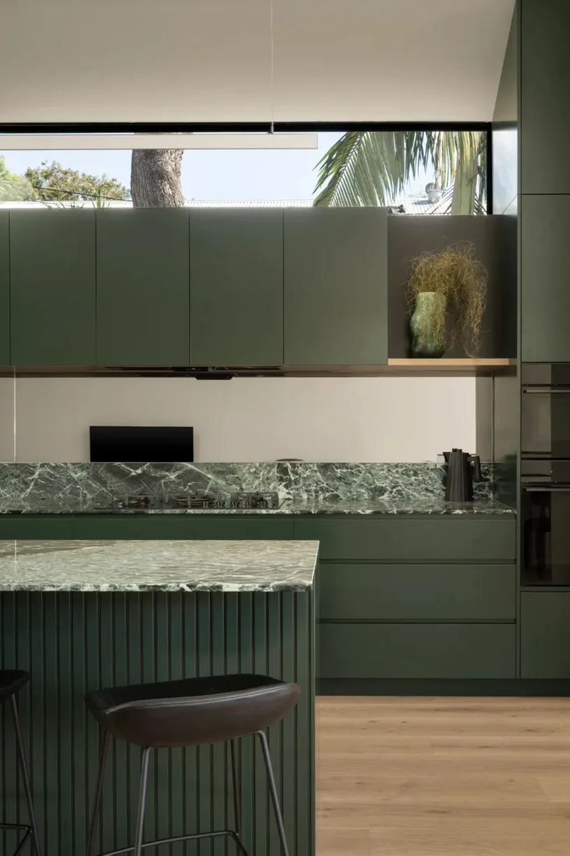 Green kitchen with stone benchtops at FOLAR’s Red Hill House in Brisbane