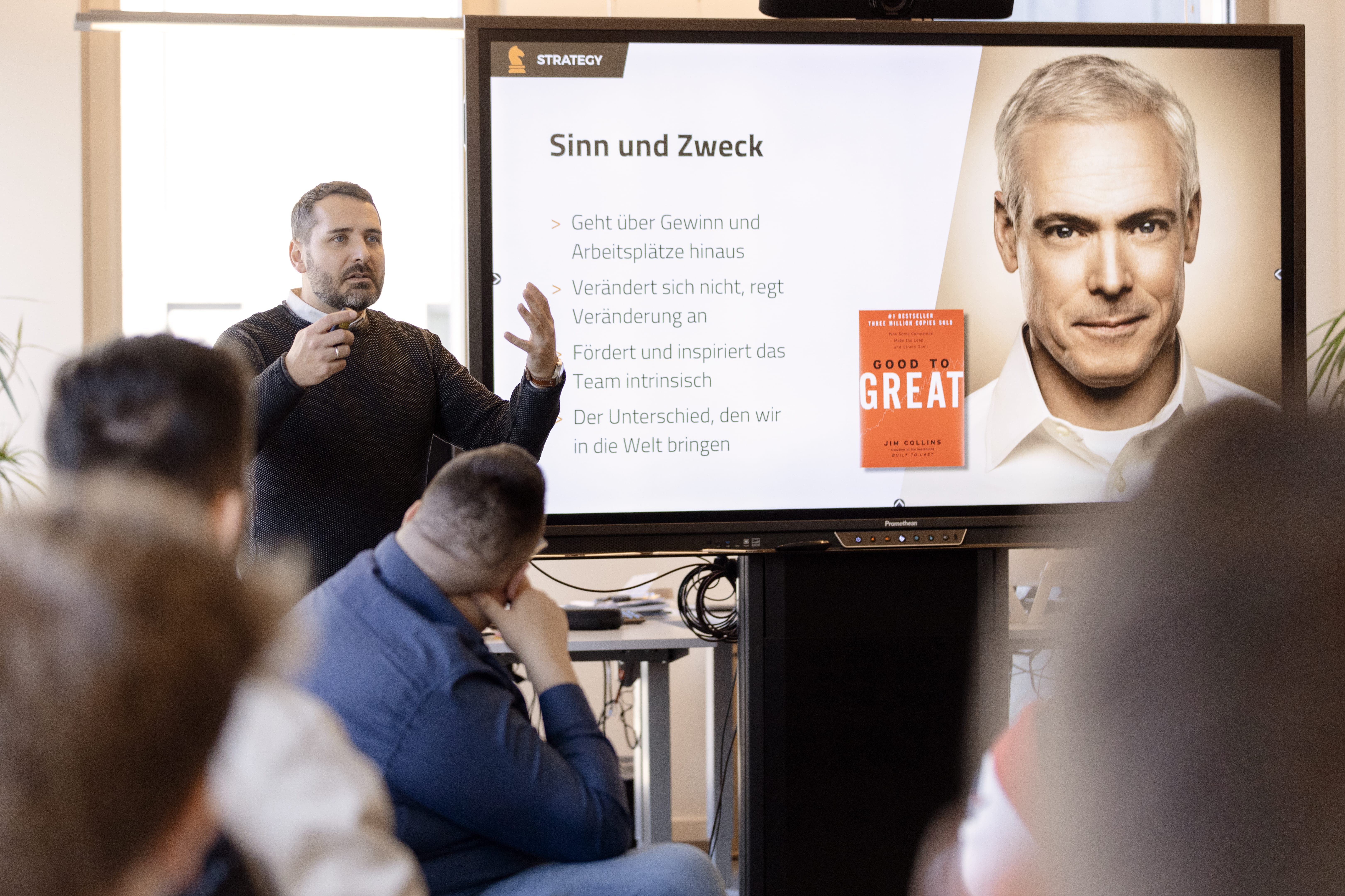 Mann hält Präsentation über Strategie zum Buch 'Good to Great' vor Zuhörern.