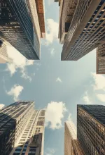 Person mopping a shiny floor near large windows with city view in the background.