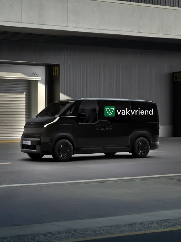 Zwarte bestelwagen geparkeerd in een industriële omgeving met het logo van Vakvriend op de zijkant.